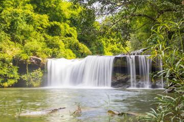 Waterfall in the deep forest. River stream waterfall in the forest landscape. Leaf moving low-speed shutter blur. Ubon Ratchathani, Thailand, Asia.