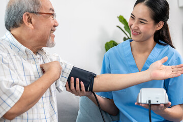 A contented retired man having a blood pressure check by his personal caregiver at his home with a...