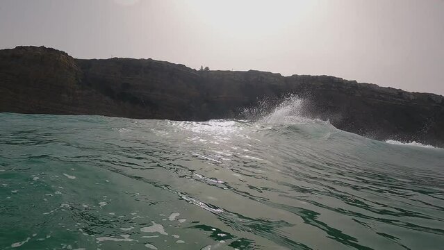Surfer surfing tropical ocean wave generating a lot of speed at Praia da Aguda in Portugal