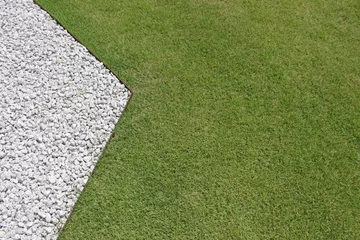 Foto op Canvas Blank background from above view of the contrast between an angled straight edge of white stone gravel and green garden lawn © Hi-Point