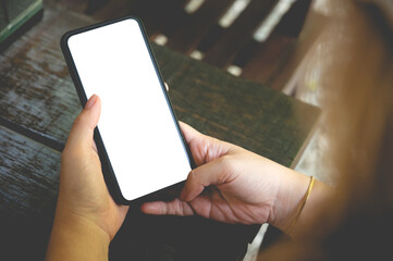 Close up women using a smartphone with an empty white screen at the wooden interior cafe.