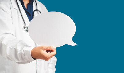 Doctor in uniform holding a white blank speech bubble while standing on a blue background