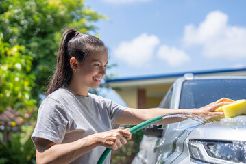 Women washing cars at home on vacation.