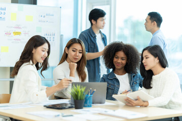 Business people showing team work while working in board room in office interior. People helping one of their colleague to finish new business plan. Business concept. Team work.