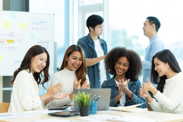 Business people showing team work while working in board room in office interior. People helping one of their colleague to finish new business plan. Business concept. Team work.