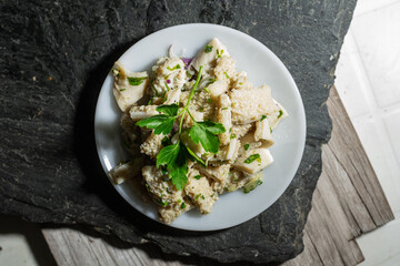 dish of buseca tripe with garlic and parsley on a black background