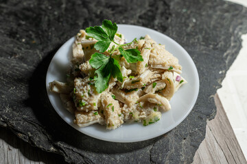 dish of buseca tripe with garlic and parsley on a black background mondongo