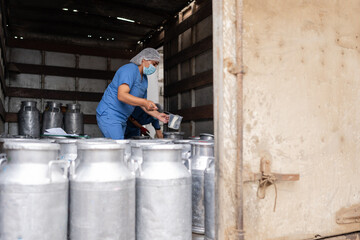 Worker in a truck taking samples of milk