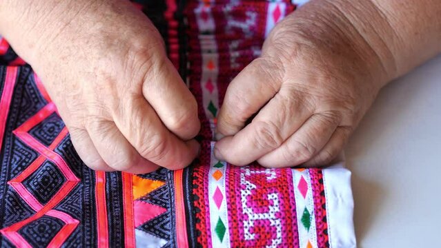 Handheld close up hand sewing make Hmong skirt, Making Hmong skirt