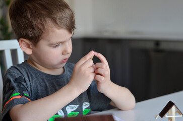 boy glues the details of the craft