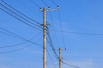 青空に線画を描く電柱と電線