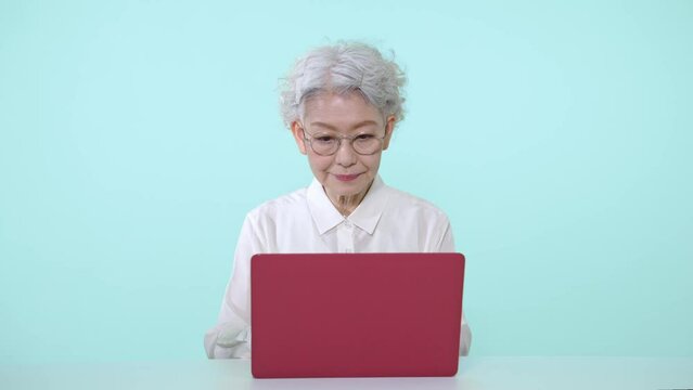 ノートパソコンを使うシニア女性