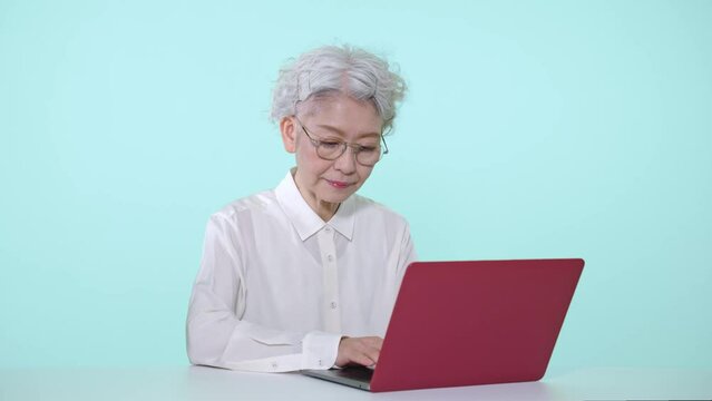 ノートパソコンを使うシニア女性