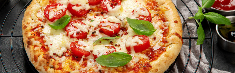 Freshly baked pizza on dark background.