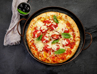 Freshly baked pizza on dark background.