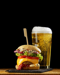 Delicious homemade hamburger and beer on a wooden table, fast food, close-up