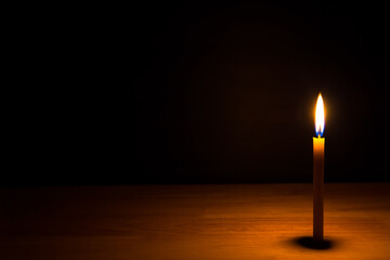 Candle light on the wooden table in the dark night. picture for art work design or add text message.