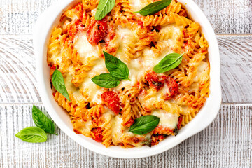 Close up of Pasta alla sorrentina. Spiral shape fusilli pasta oven baked in casserole with tomato...