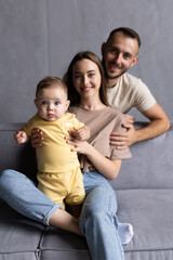 Happy young family on their sofa at home
