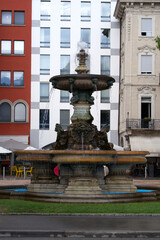 Obraz premium Fountain with bronze memorial of Antonio Bossi at City of Lugano on a cloudy summer day. Photo taken July 4th, 2022, Lugano, Switzerland.