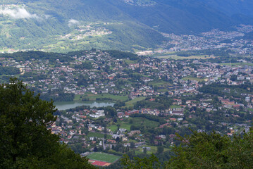 Scenic landscape seen from local mountain San Salvatore, Canton Ticino, over Lake Muzzano on a cloudy summer day. Photo taken July 4th, 2022, Lugano, Switzerland.