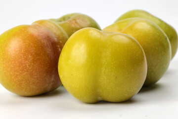 Small mini green fresh juicy plum fruit on white background