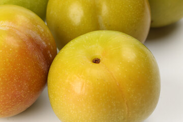 Small mini green fresh juicy plum fruit on white background