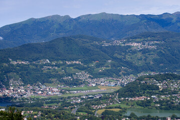 Scenic landscape seen from local mountain San Salvatore, Canton Ticino, over Lake Muzzano on a cloudy summer day. Photo taken July 4th, 2022, Lugano, Switzerland.