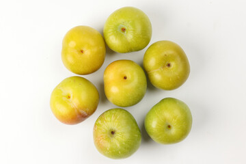 Small mini green fresh juicy plum fruit on white background