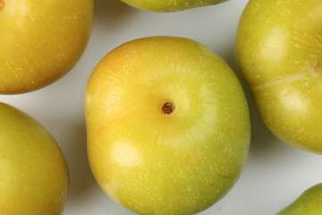 Small mini green fresh juicy plum fruit on white background