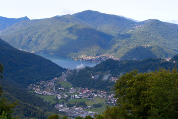 Fototapeta na wymiar Aerial view from local mountain San Salvatore over region of Lugano, Canton Ticino, with Lake Lugano on a cloudy summer day. Photo taken July 4th, 2022, Lugano, Switzerland.