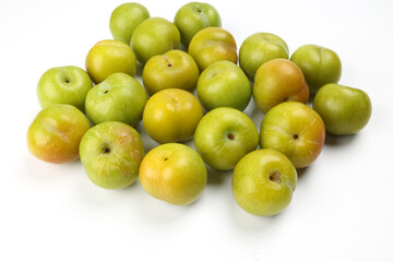 Small mini green fresh juicy plum fruit on white background cut slice half seed many pile