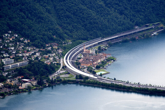 Scenic landscape with mountain panorama and dam with village of Bissone seen from local mountain San Salvatore at City of Lugano on a summer day. Photo taken July 4th, 2022, Lugano, Switzerland.