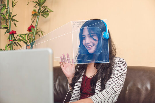 A laptop using facial recognition AI technology to verify an employee's identity for attendance. Automated remote personnel behavior tracking and online monitoring.