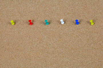 a colorful pins on a wooden board.