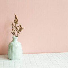 Home interior decor, vase of dry plant on white table. pink wall background