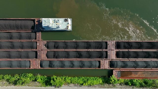 Top down aerial of barge in water. Coal transported on river in USA.