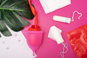 woman tampon and a sanitary napkin, menstrual cup on a pink background, menstrual period, PMS and...