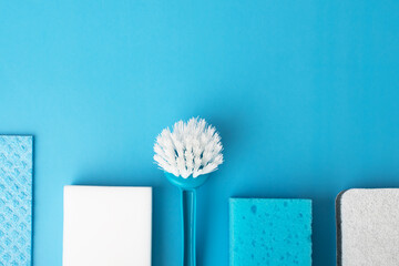 cleaning and housekeeping, cleanliness supplies, stylish cleaning accessories, brush sponge and rag on blue background, copy space