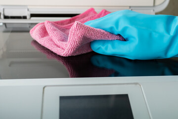cleaning service, disinfection, hand in glove wipes dust from a printer with a rag