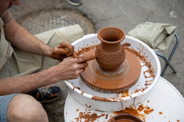 A potter makes a pot on a circle. The hands of the master create from clay. Man making ceramic pot.