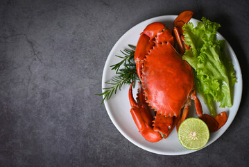 seafood crab cooking food boiled or steamed crab red in the seafood restaurant, fresh crab on white plate dark background - top view