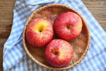 apple fruit on basket on the wooden table, ripe red apples
