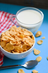 cornflakes bowl breakfast food and snack for healthy food concept, morning breakfast fresh whole grain cereal, cornflakes with milk on blue background