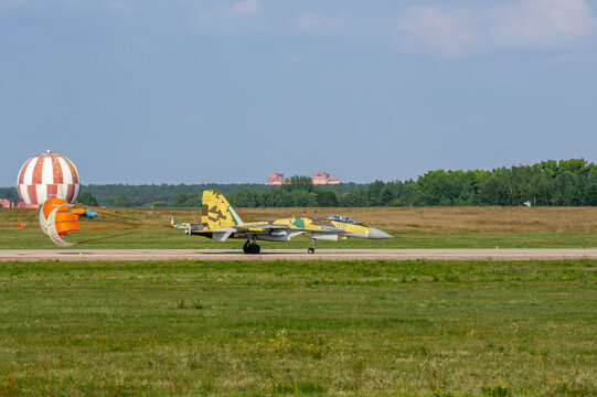 MAKS-2011. Soviet-Russian multi-purpose fighter Su-35 (NATO - Flanker-E) lands on concrete runway. Behind aircraft, braking parachute is orange. Close-up. Zhukovsky, Russia - August 16, 2011