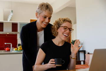 Mother and daughter talking on video call over laptop