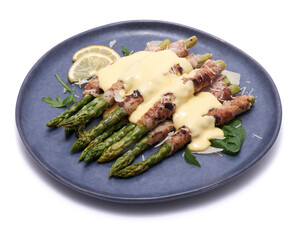 Healthy food - Asparagus wrapped with bacon and spices on a plate isolated on white background
