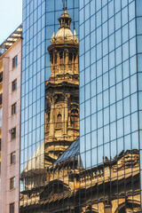 Fototapeta na wymiar reflection of church tower on an office building