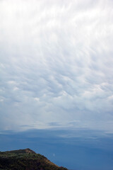 Stratocumuliform of cirrus clouds illuminated by the afterglow of sunset over a dark blue sky.