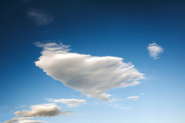 Large and small clouds scattered in a blue sky.